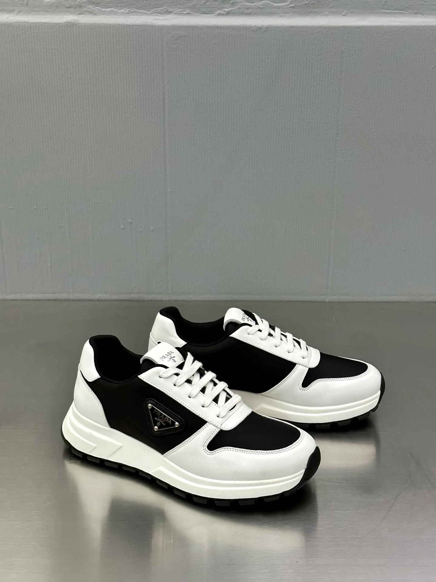 💰740 Prada/Prada men's new mesh stitching sneakers. This sneaker presents a modern version, reinterpreting the brand's archive style with clean lines and smooth details. The shoes are made of calf leather and technical fabric, with a triangular metal logo on the outside, bright TPU decoration on the heel, and a longer and padded inner heel design for a more comfortable fit. The tongue is decorated with a silk-screen logo, and is paired with a hollow rubber sole on the heel. The full cowhide lining comes standard with logo cowhide foot pads, making the upper foot taller, more comfortable, and versatile! Comes with full original packaging! Size: 39-40-41-42-43-44 standard leather shoe size (45 can be customized and does not support returns)